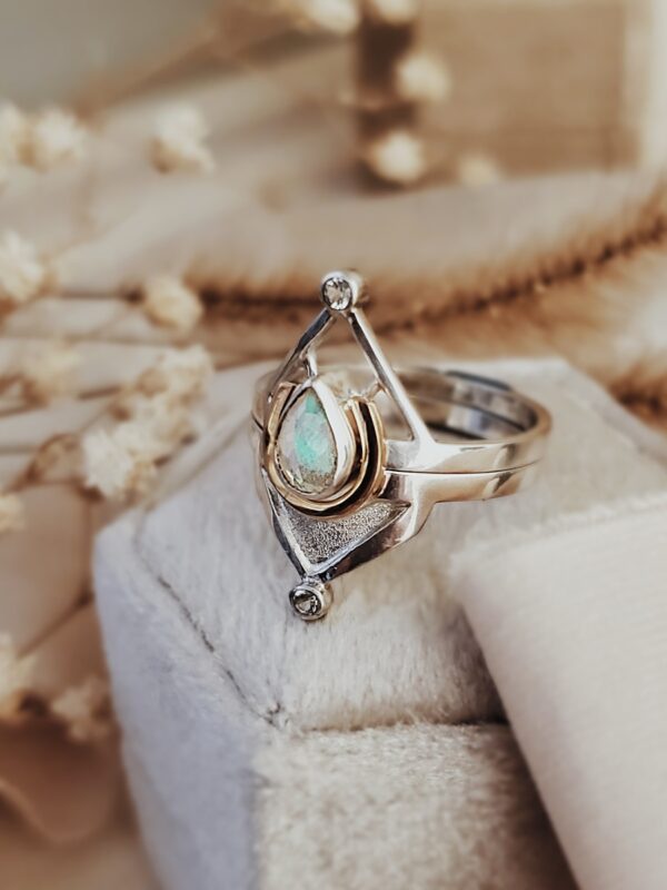 Mars Ring Set featuring a 7x5mm Welo Opal with tiny moissanite accents, sterling silver and 14k gold, with dried flowers nearby.