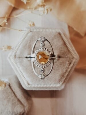 Jupiter ring set in sterling silver featuring an 8mm citrine center stone with moissanite accents, displayed in a cream velvet ring box.