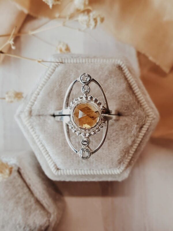 Jupiter ring set in sterling silver featuring an 8mm citrine center stone with moissanite accents, displayed in a cream velvet ring box.