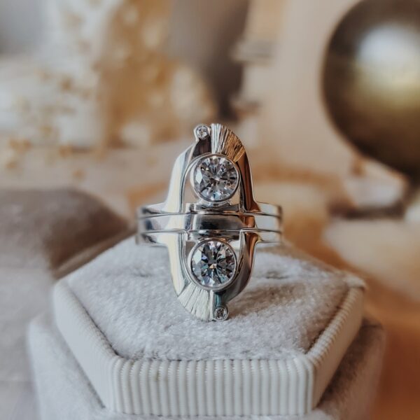 Messenger of Light Mercury Ring Set with sparkling moissanite stones displayed on a cream velvet ring box.
