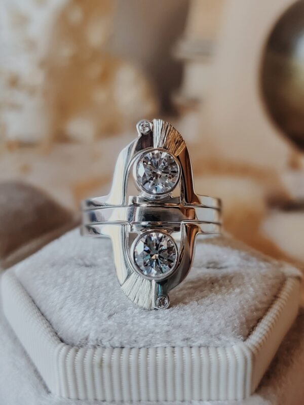 Messenger of Light Mercury Ring Set with sparkling moissanite stones displayed on a cream velvet ring box.