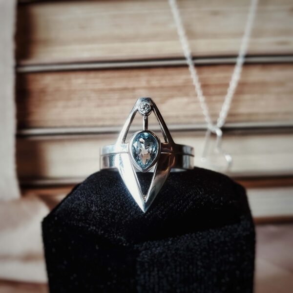 Sterling silver Neptune ring set with pear aquamarine and moissanite accent, inspired by a trident design.