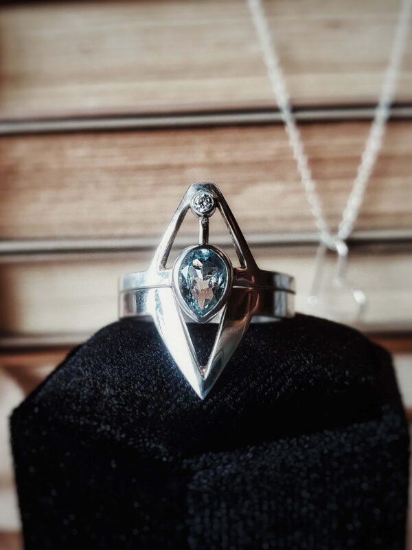 Sterling silver Neptune ring set with pear aquamarine and moissanite accent, inspired by a trident design.