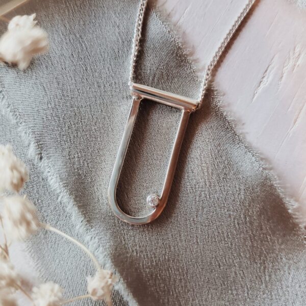 Salana – elongated silver modern arch necklace with moissanite.