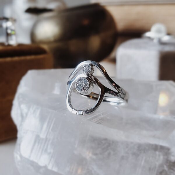 Sterling silver wave arch ring with two moissanite stones, featuring curved arches and layered movement