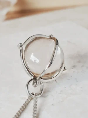 Detail view of sterling silver orbital framework surrounding a 20mm natural rock crystal quartz sphere